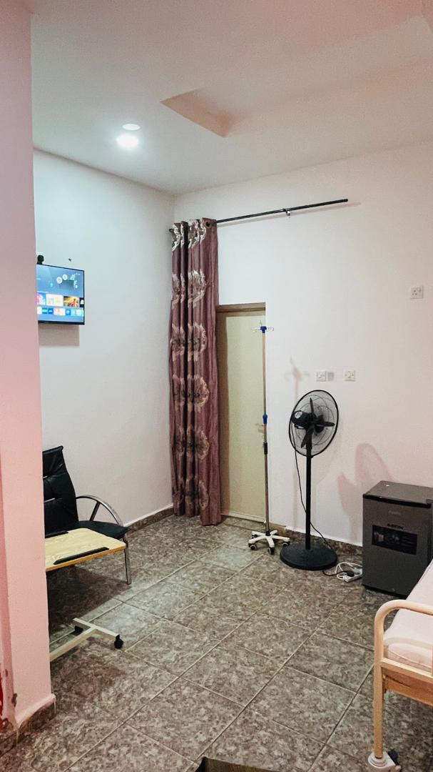 Patient room with mounted television and mini fridge